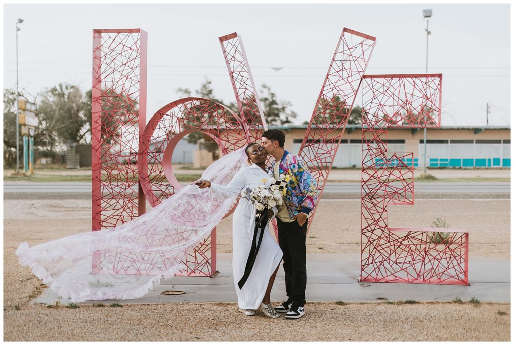 love with a couple in front of the sign