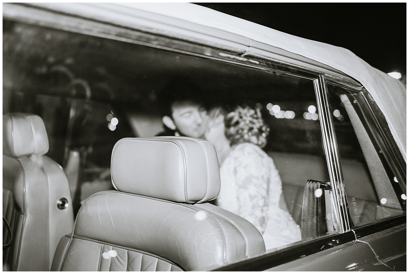 bride and groom in their getaway car leaving the wedding venue